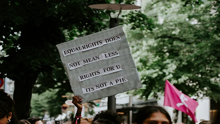 The picture shows a handmade protest sign bearing the slogan “EQUAL RIGHTS DOES NOT MEAN LESS RIGHTS FOR YOU – IT’S NOT A PIE”.